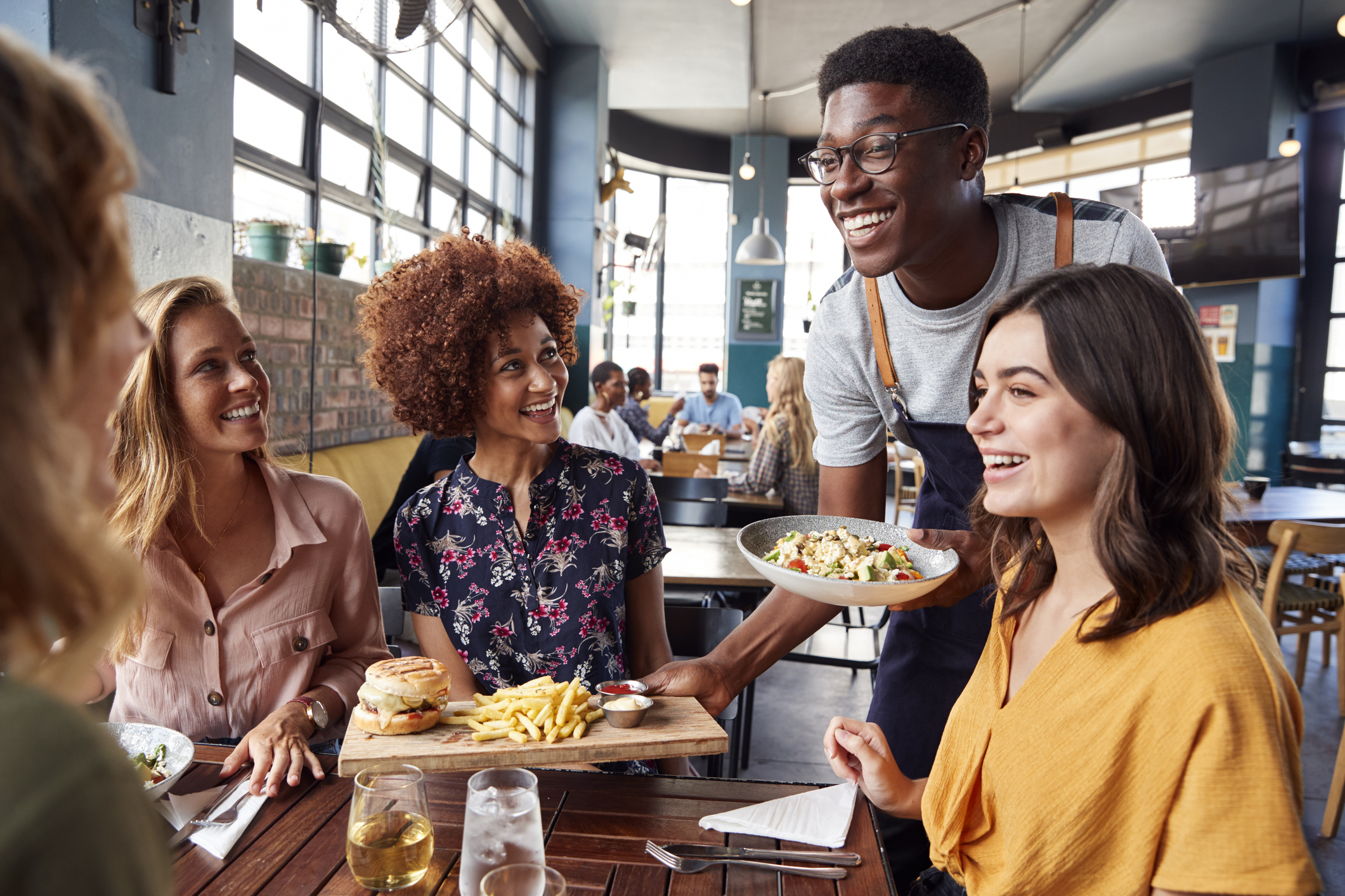 Friends at restaurant table being served